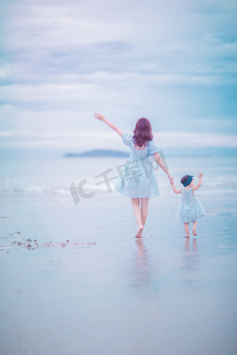 亲子时光傍晚年轻妈妈和女儿户外沙滩一边招手一边走路摄影图配图图片