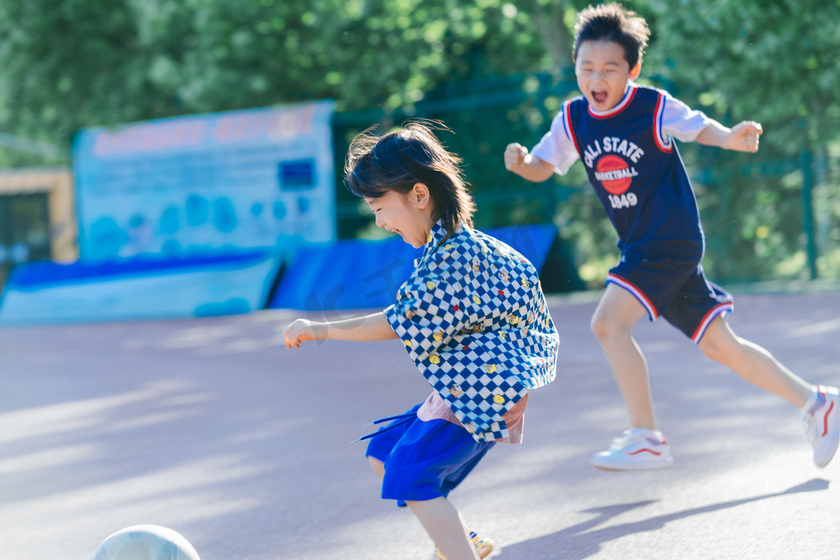 夏日两人儿童人像白天两个男孩操场一起踢球摄影图配图图片