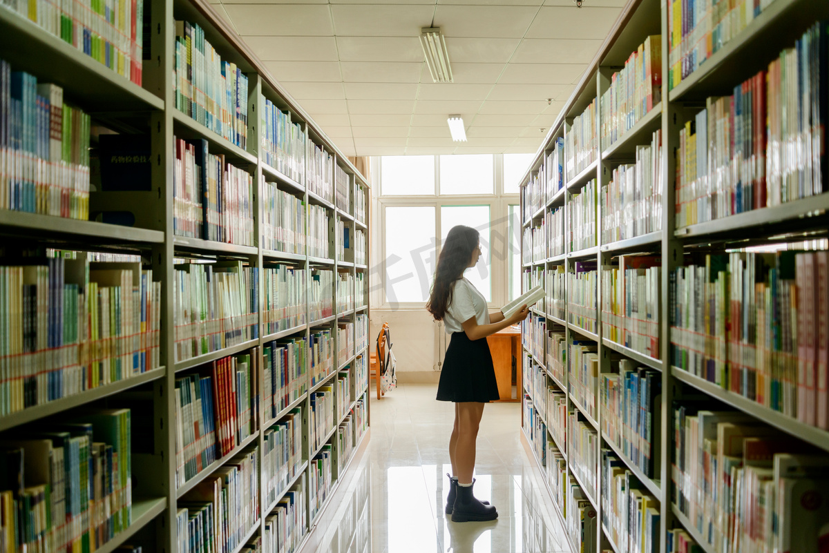 人像白天女孩子书架前看书摄影图配图图片