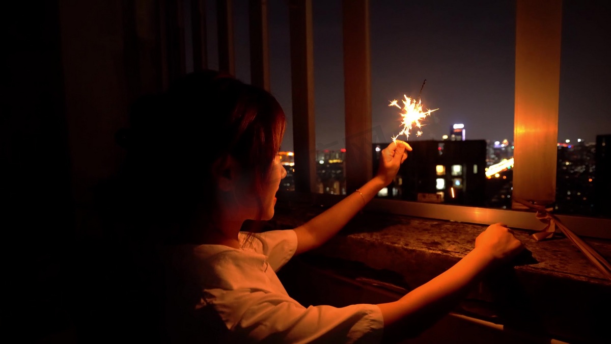 女孩夜晚点亮烟花棒图片