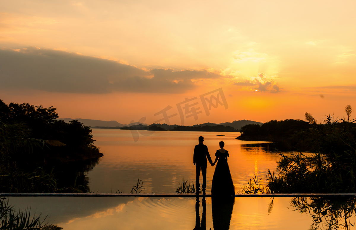 七夕情人节婚纱摄影图配图夕阳两个人湖边牵手摄影图配图图片
