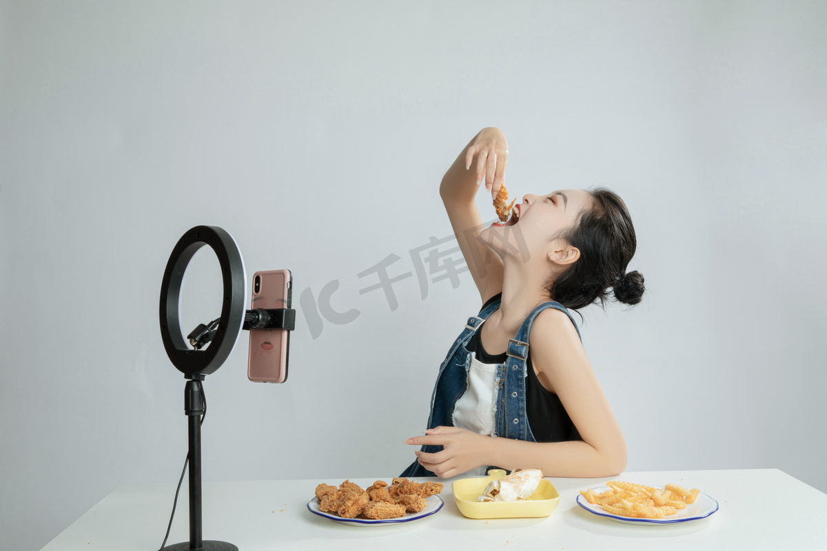 美食主播直播大口吃鸡块平拍摄影图配图图片