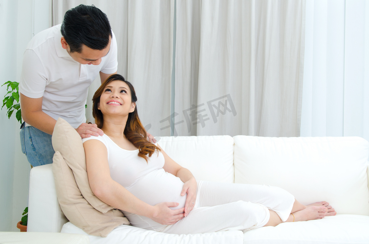 男人和他怀孕的妻子微笑着互相对视图片