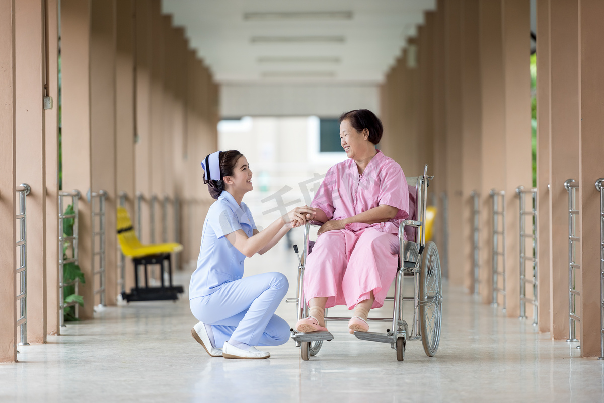 高级别的女性轮椅跟护士说话图片