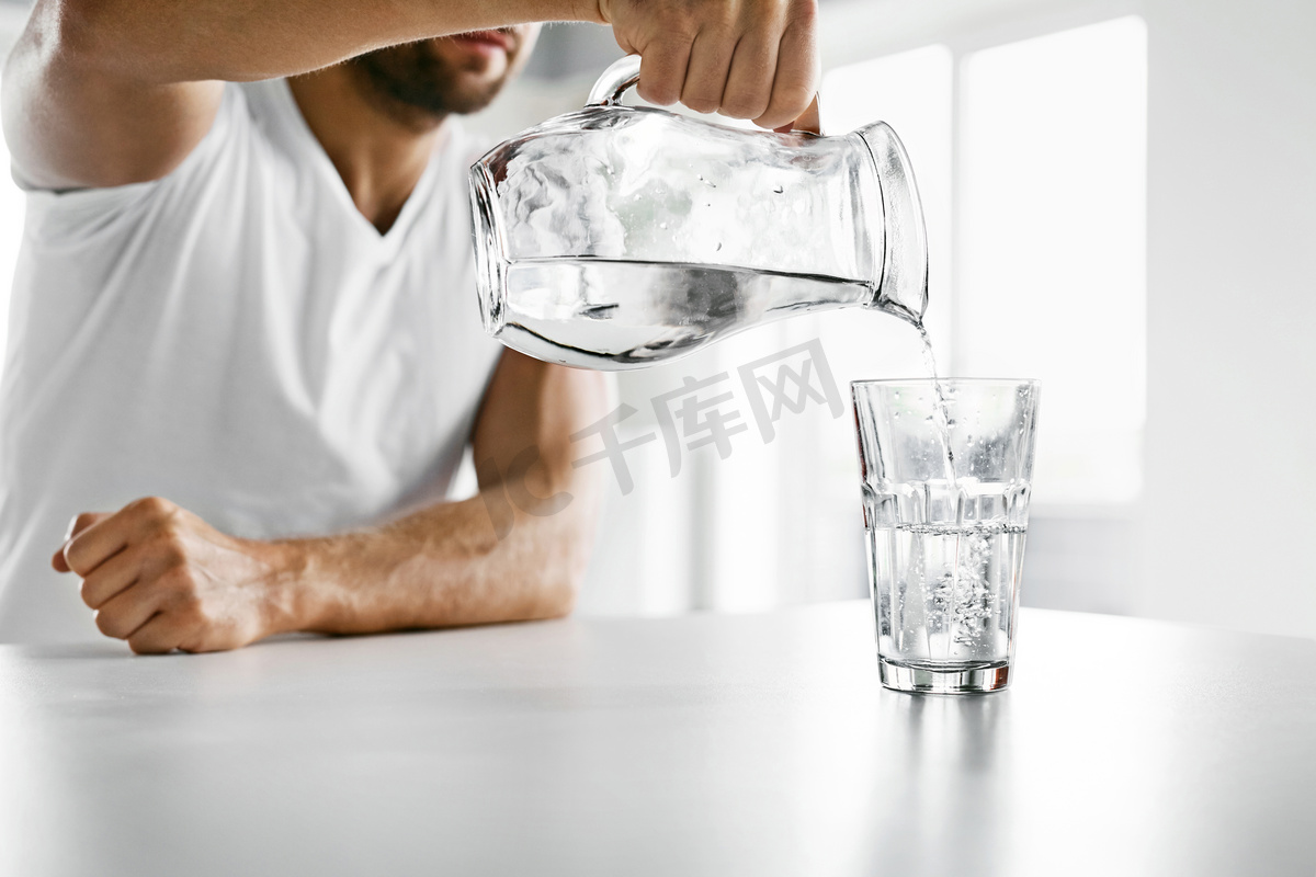 喝水。特写人把水倒进玻璃里。水化图片