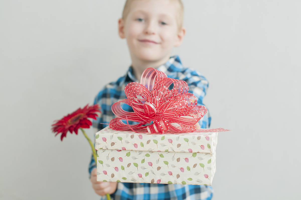 小男孩与红色的花及礼品盒图片