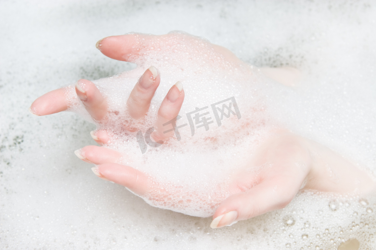 女人的手在浴与泡沫图片