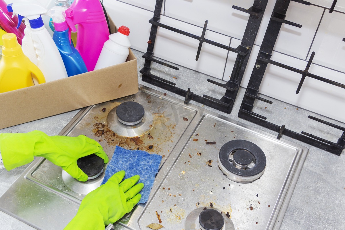 用厨房用具、家庭观念或卫生和清洁来清洁煤气炉.图片