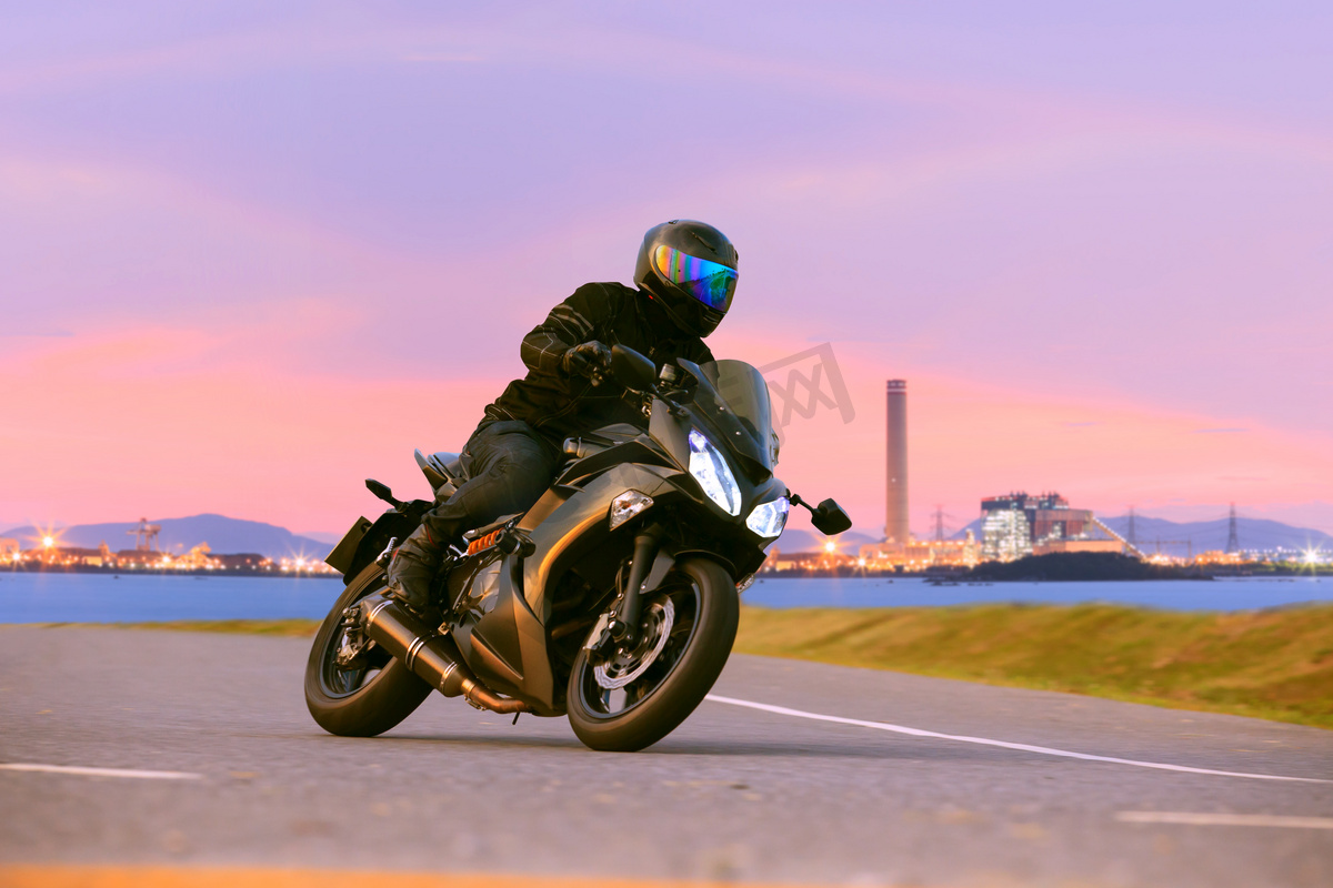 年轻男子骑马运动巡回摩托车在沥青高速公路股份公司图片