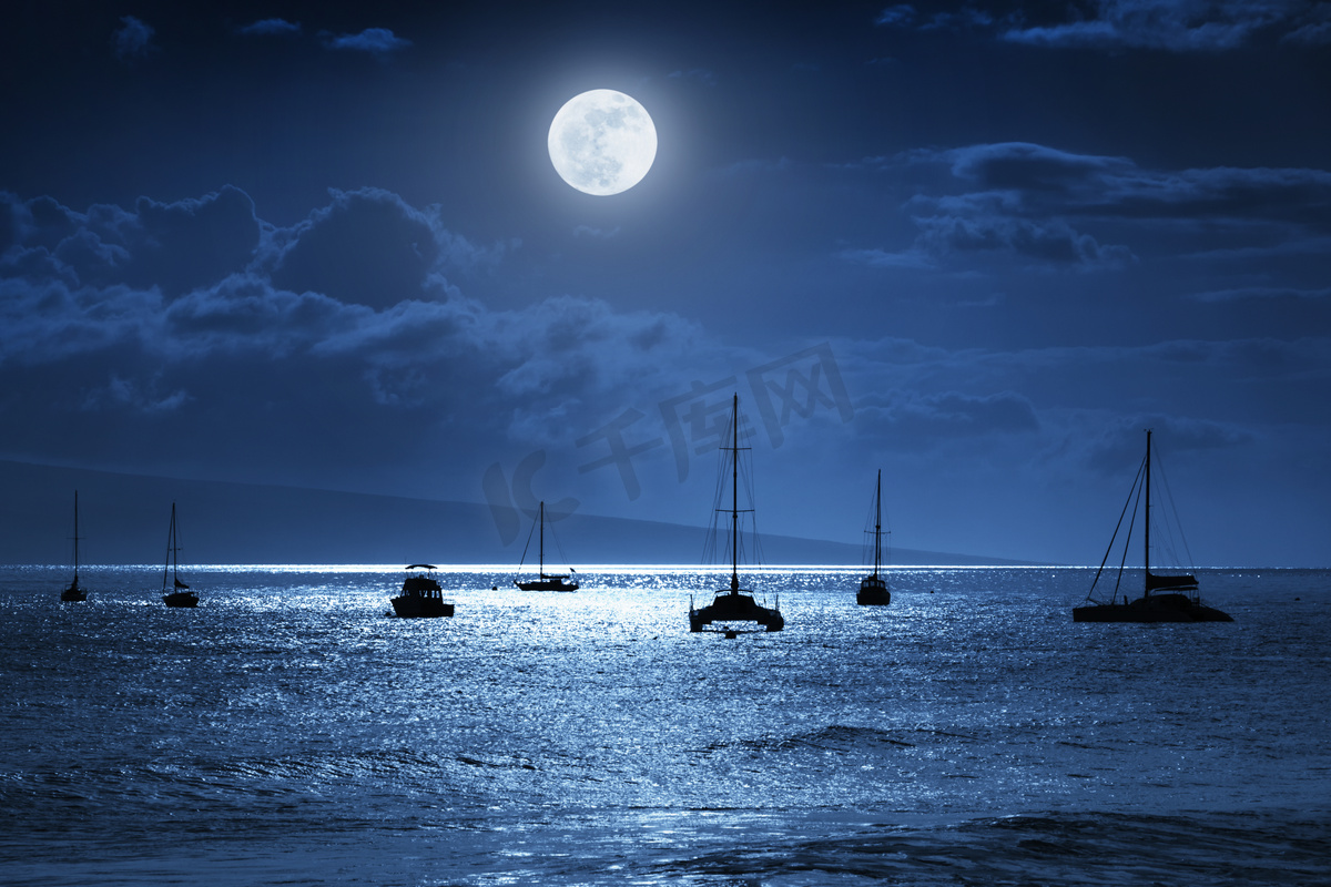This dramatic photo illustration of a nighttime sky over a calm ocean scene in Maui, Hawaii with brightly lit clouds, a large, full, Blue Moon, calm waves, and sparkling reflections would make a great background for many travel or vacation uses图片