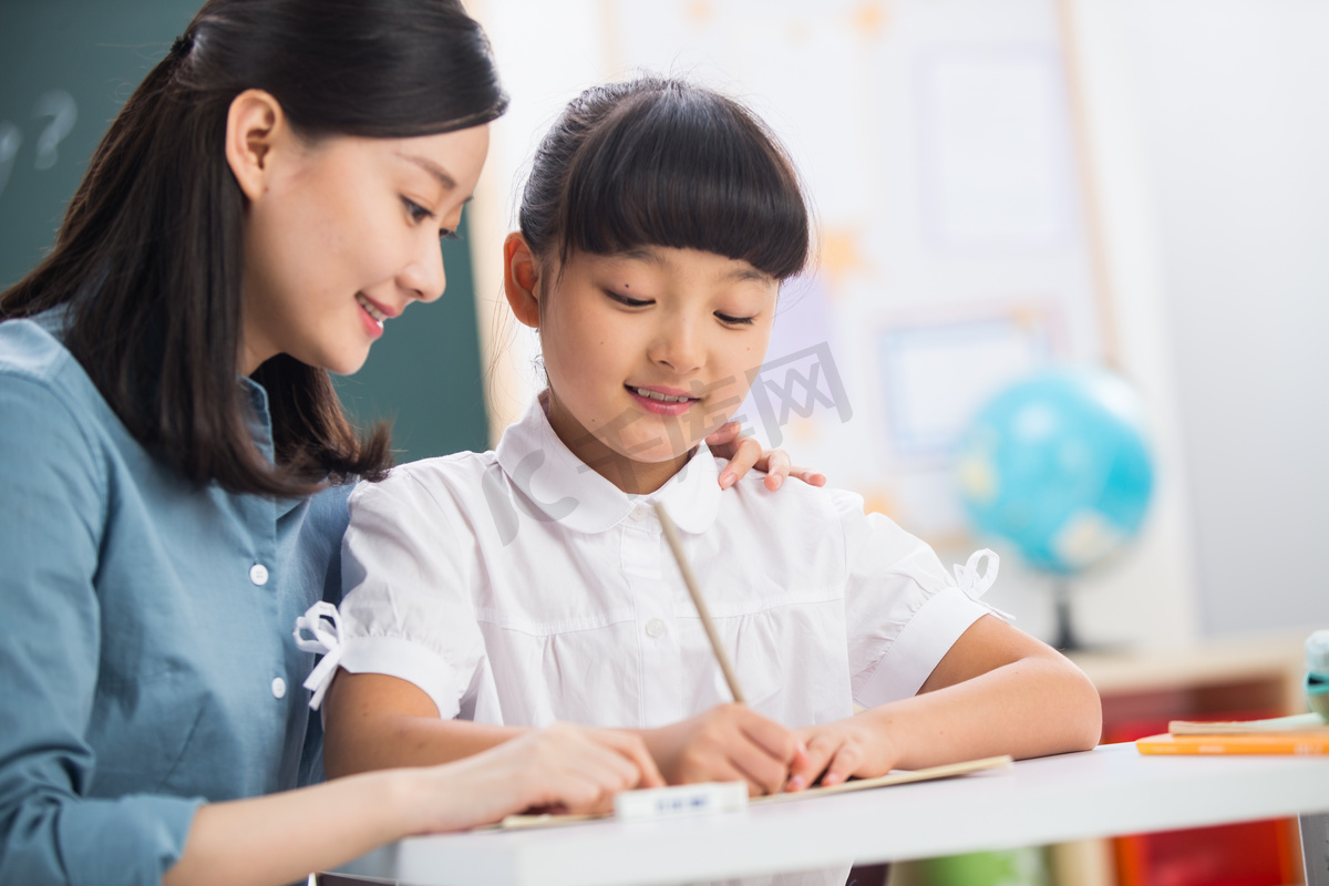 老师在指导小学女生学习图片