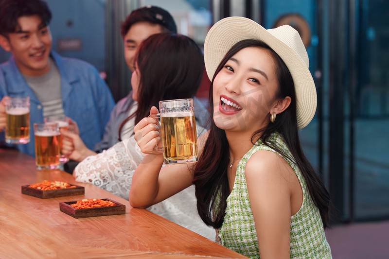 青年女人和朋友在酒吧喝酒图片