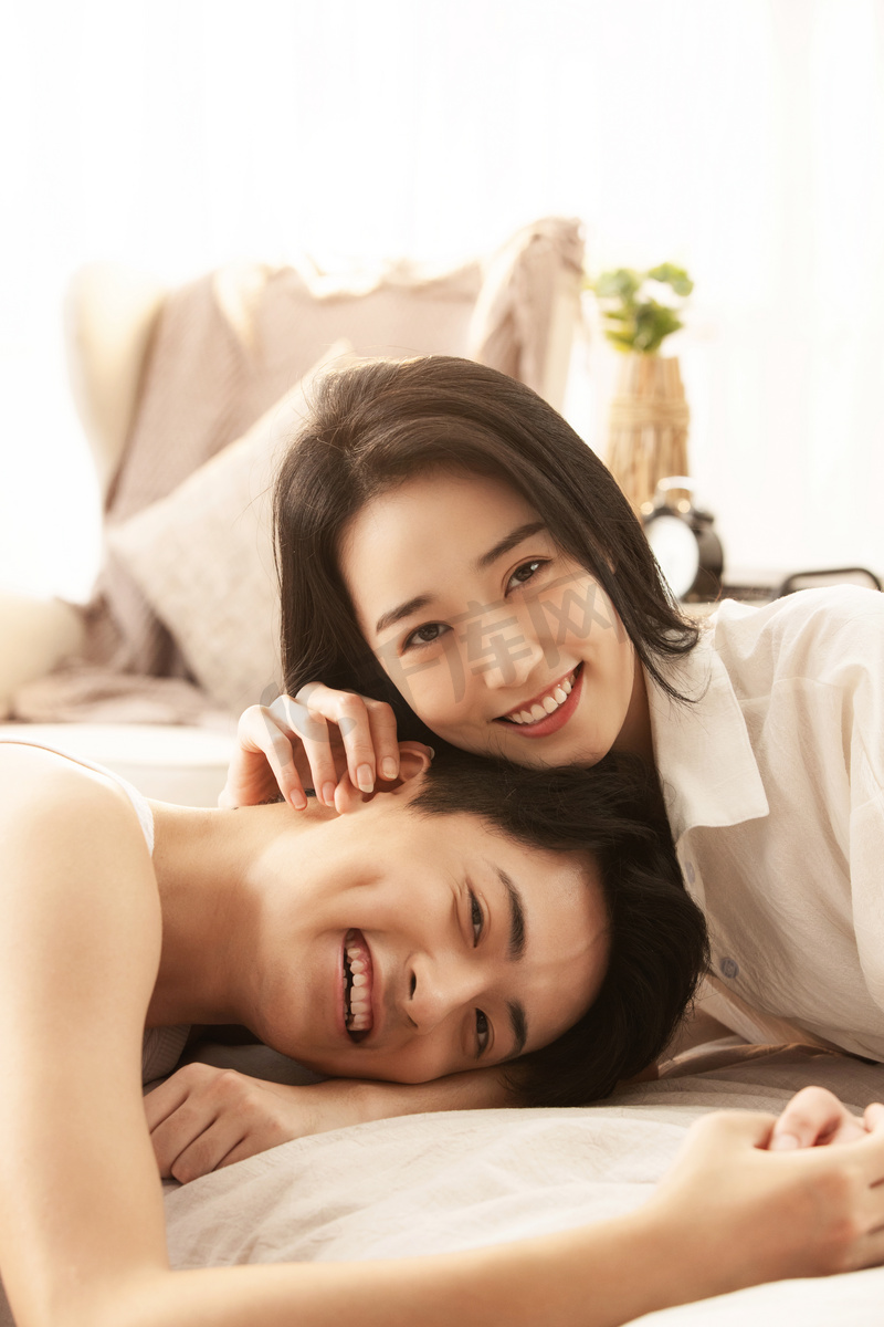 快乐的年轻情侣在床上享受甜蜜时光图片