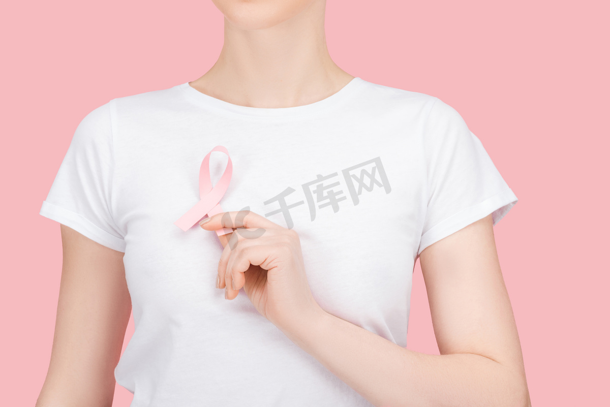 部分视图的妇女穿着白色T恤持有粉红色乳腺癌标志隔离在粉红色图片