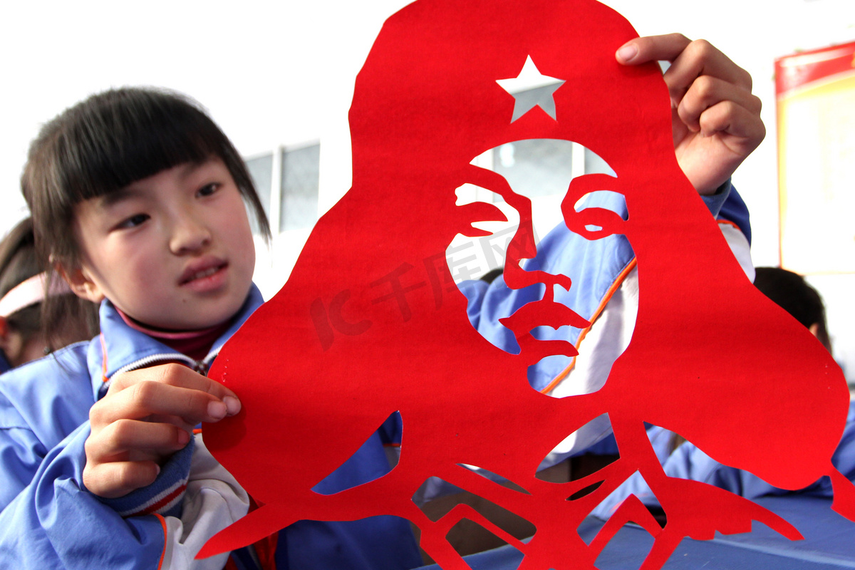 2013年3月4日，在中国东部的山东省赵庄市，一名学生展示了她的雷锋（或雷锋）头像的剪纸作品图片