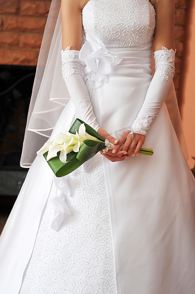 新娘身穿婚纱，手持花束图片