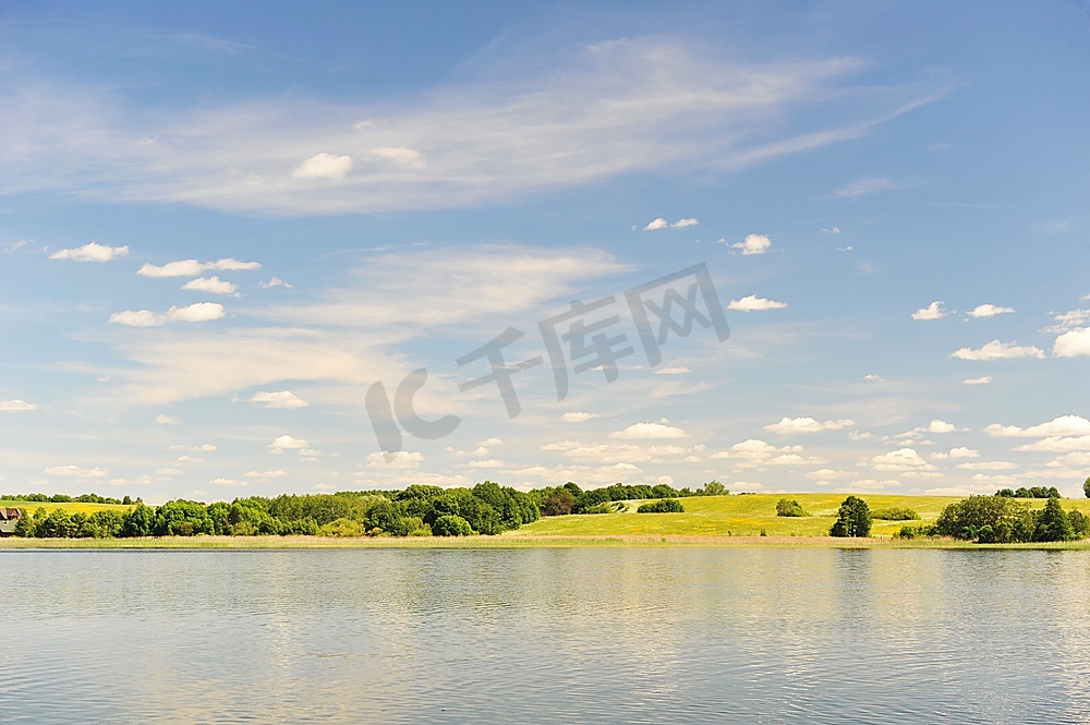平静的湖水，对岸的树林，蔚蓝的天空。景观图片