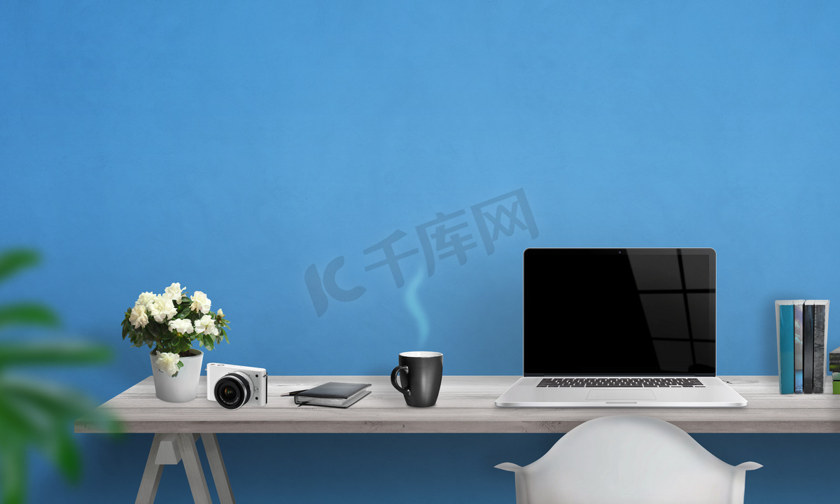 空白的屏幕，在办公室桌上的笔记本电脑。在文本的墙上的可用空间。蓝色的背景墙. 图片
