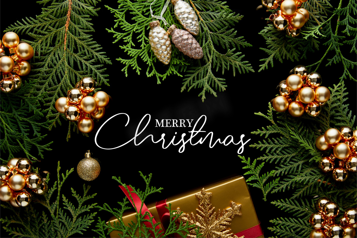 金光闪闪的圣诞装饰，绿色的thuja树枝和礼品盒的顶视图，用快乐的圣诞图解与黑色隔开图片