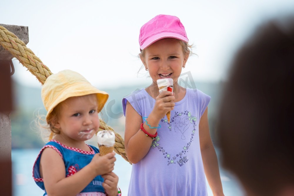 可爱的小女孩吃冰淇淋在海边在暑假期间图片