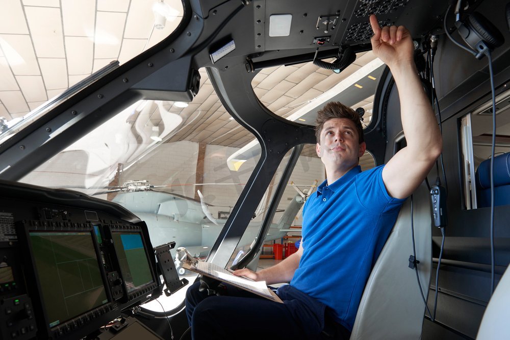 男性航空工程师与飞行员在直升机驾驶舱工作图片
