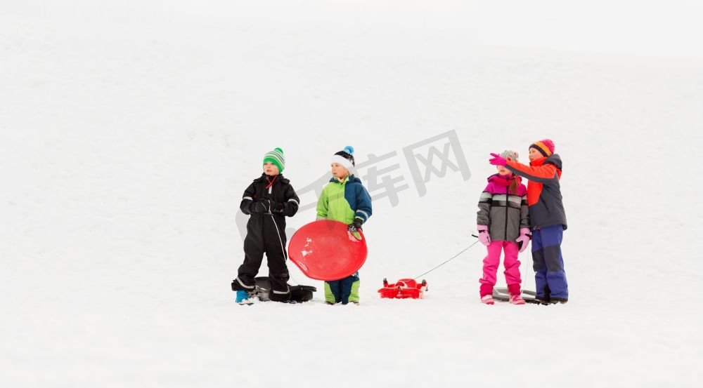 童年，雪橇和季节概念—一群快乐的小孩子在冬天雪橇。快乐的小孩子与雪橇在冬天图片