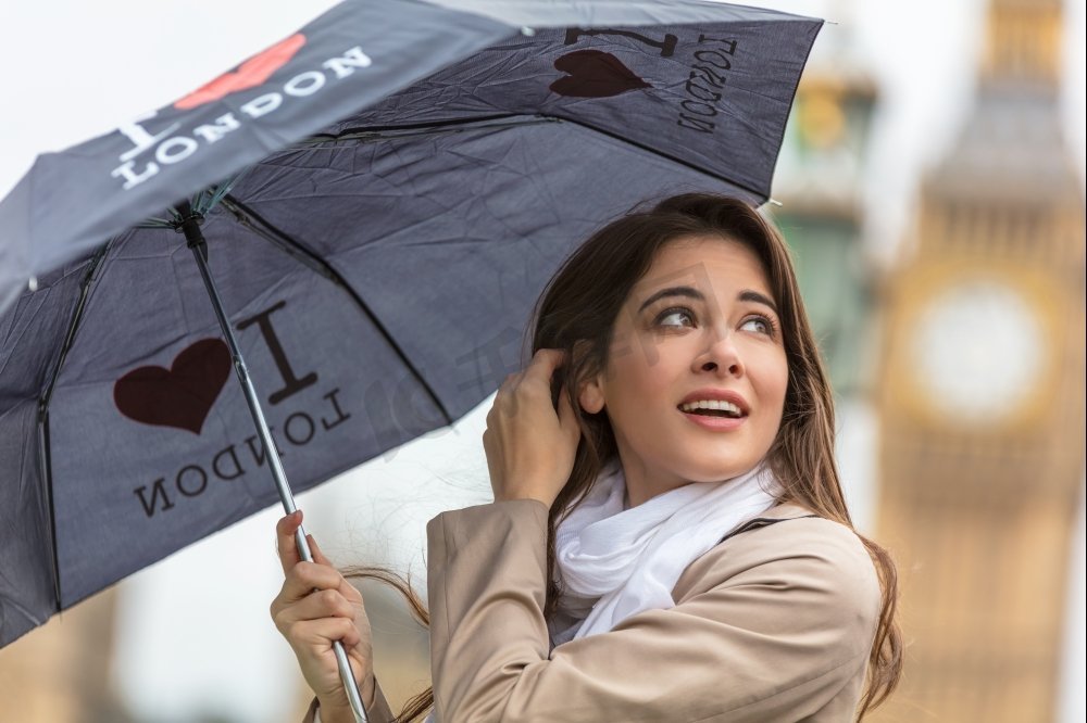 英国伦敦，带着一把背景是大本钟的我心伦敦雨伞度假的女孩或年轻女性游客图片