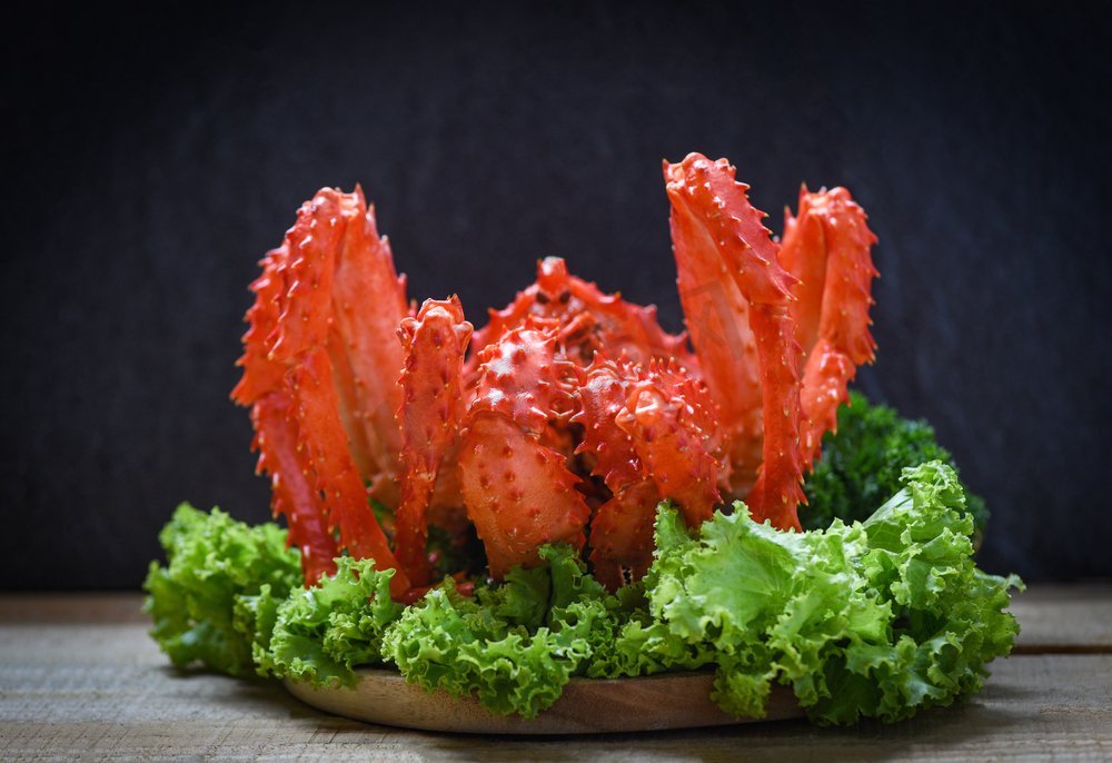 阿拉斯加国王蟹熟蒸汽或煮海鲜和生菜沙拉蔬菜与黑暗背景/红蟹北海道图片