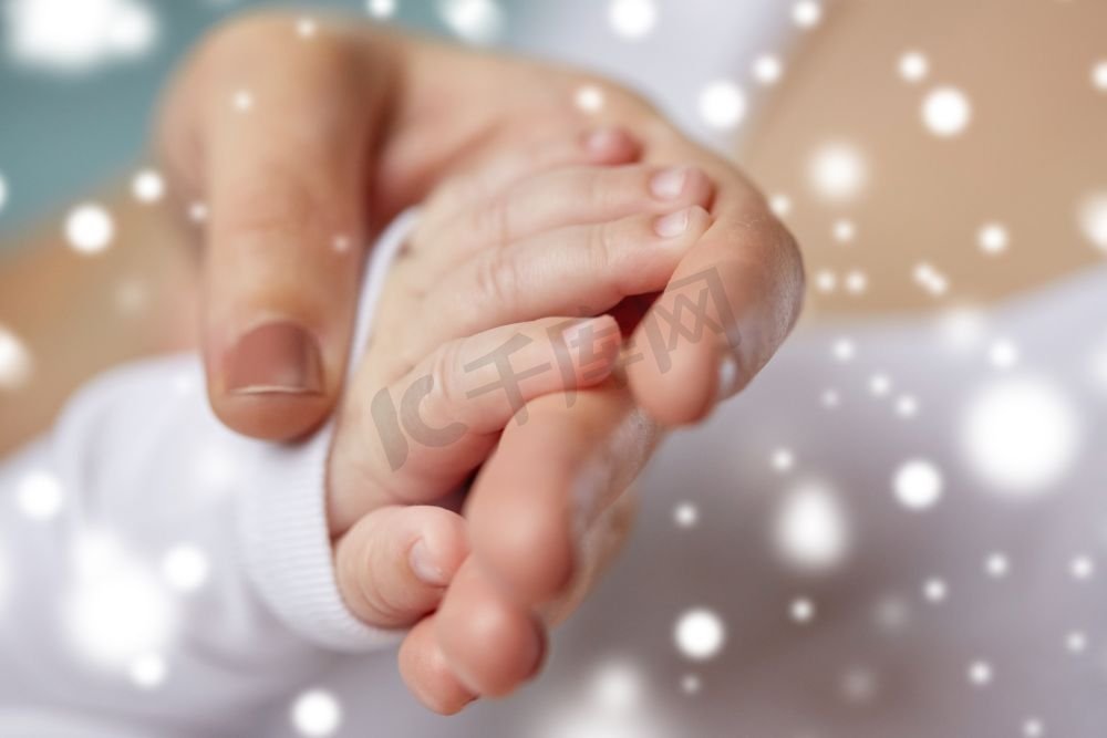 家庭、母性、人和儿童关心概念-母亲和新生婴儿近距离在雪的手近摄母亲和新生儿的手图片