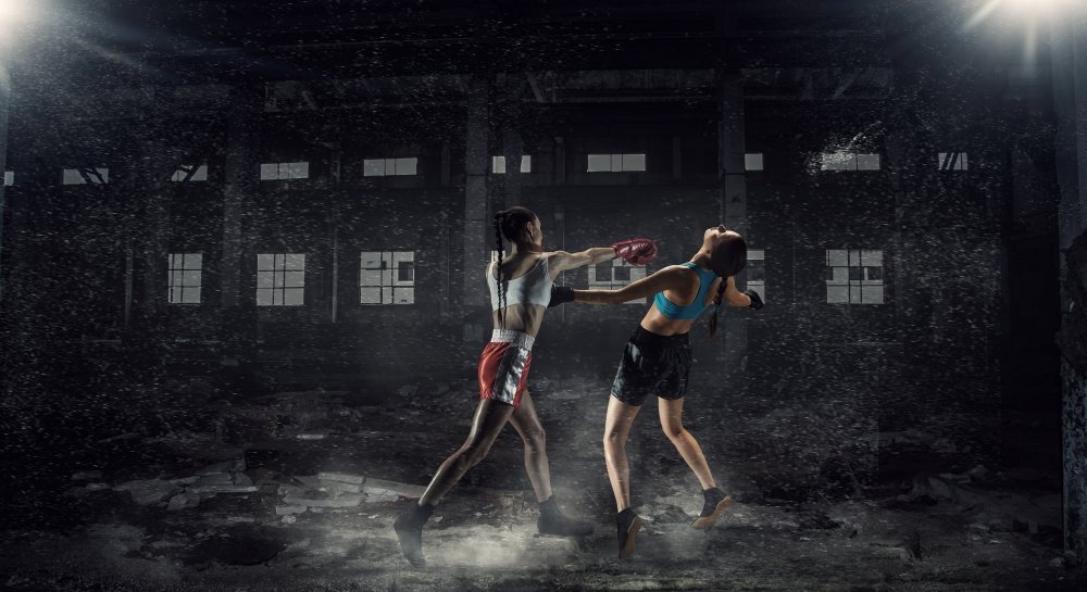 女子终极格斗。两个年轻漂亮的女人拳击在荒凉的建设。混合媒体图片
