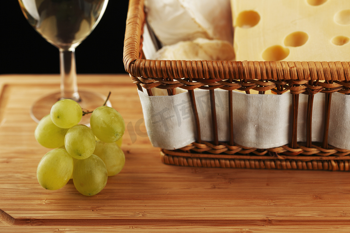 精致玻璃杯中的白葡萄酒，配奶酪和葡萄图片