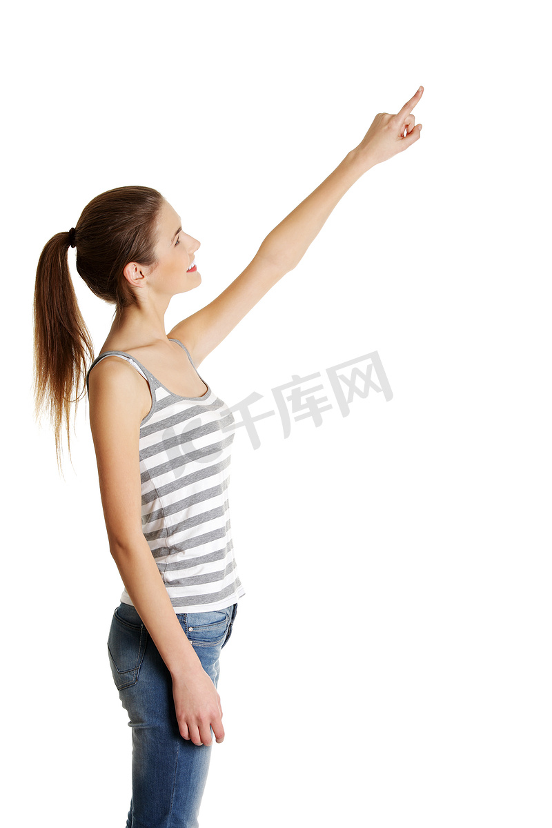女性白人青少年用手指向上指。图片