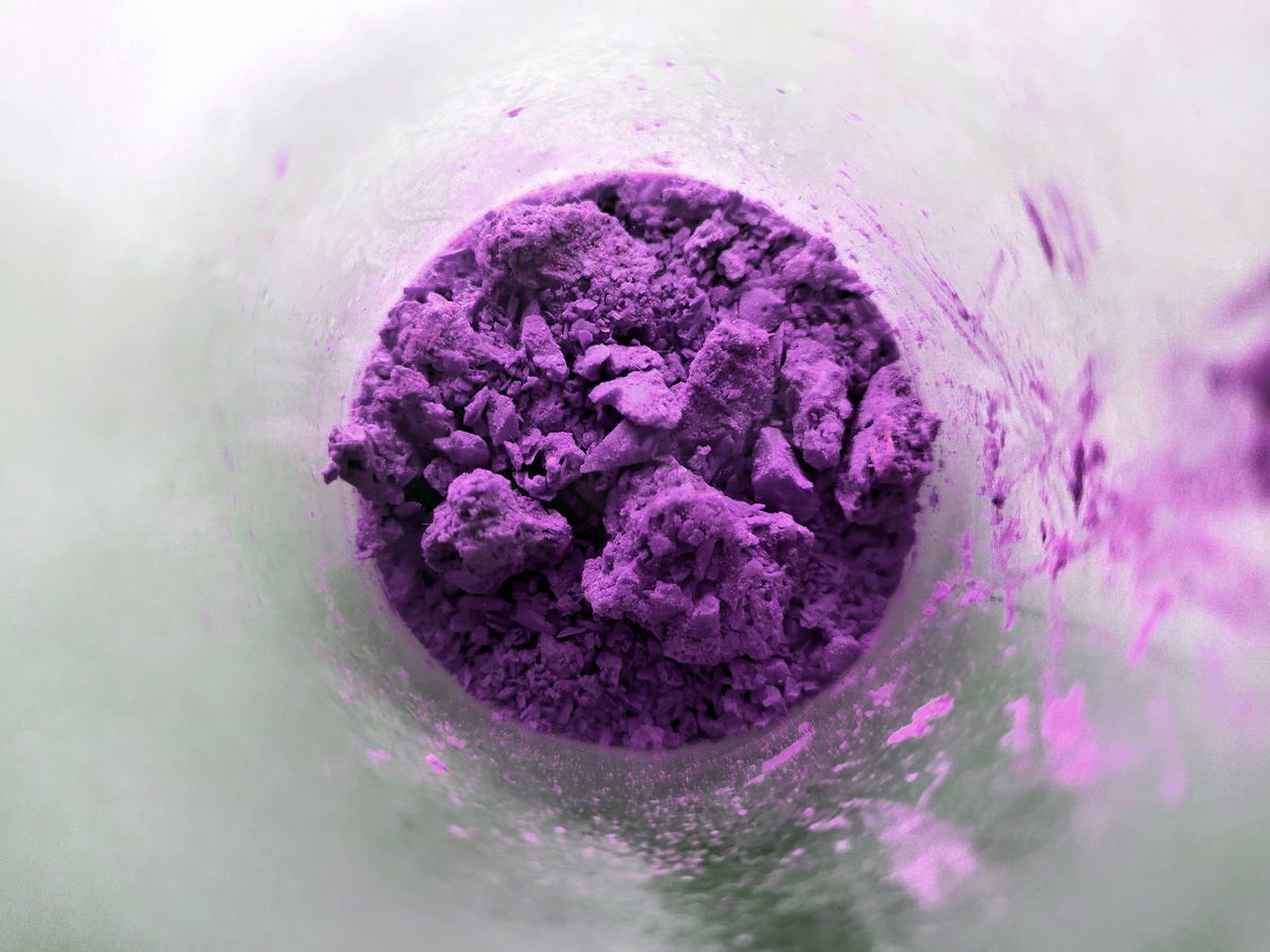 玻璃杯中的紫色粉末，装有配料的碗特写。图片