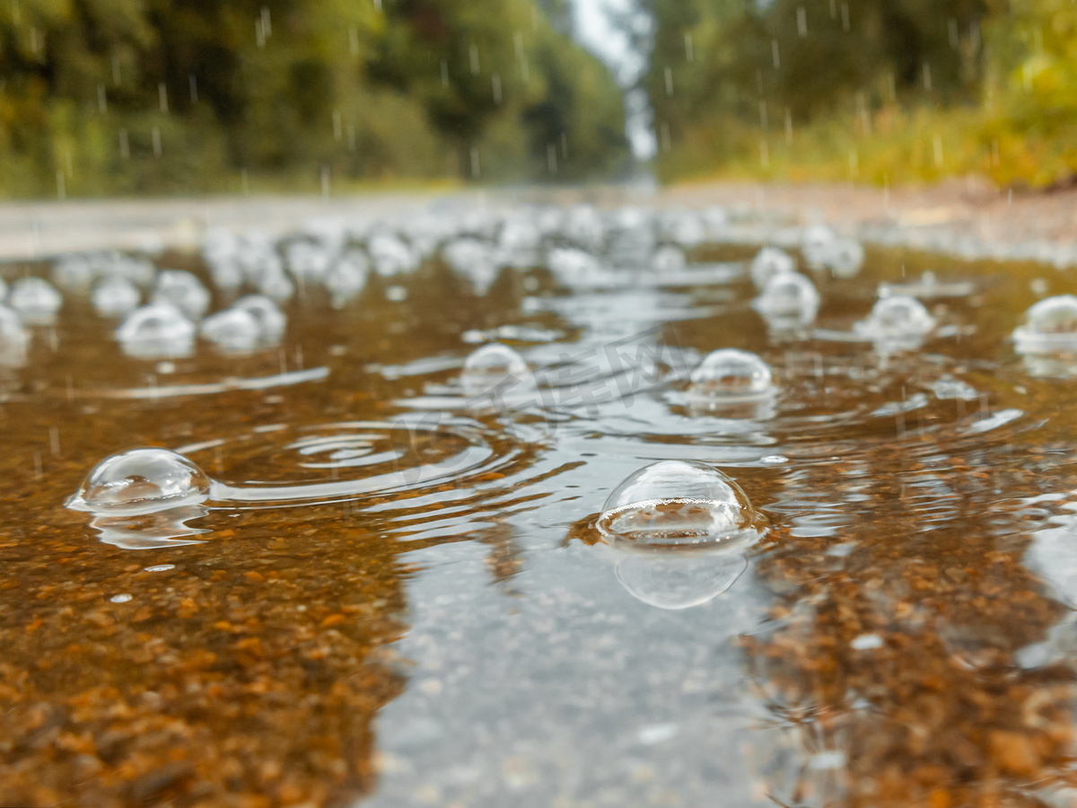 雨中路上的水坑里冒着泡泡。图片