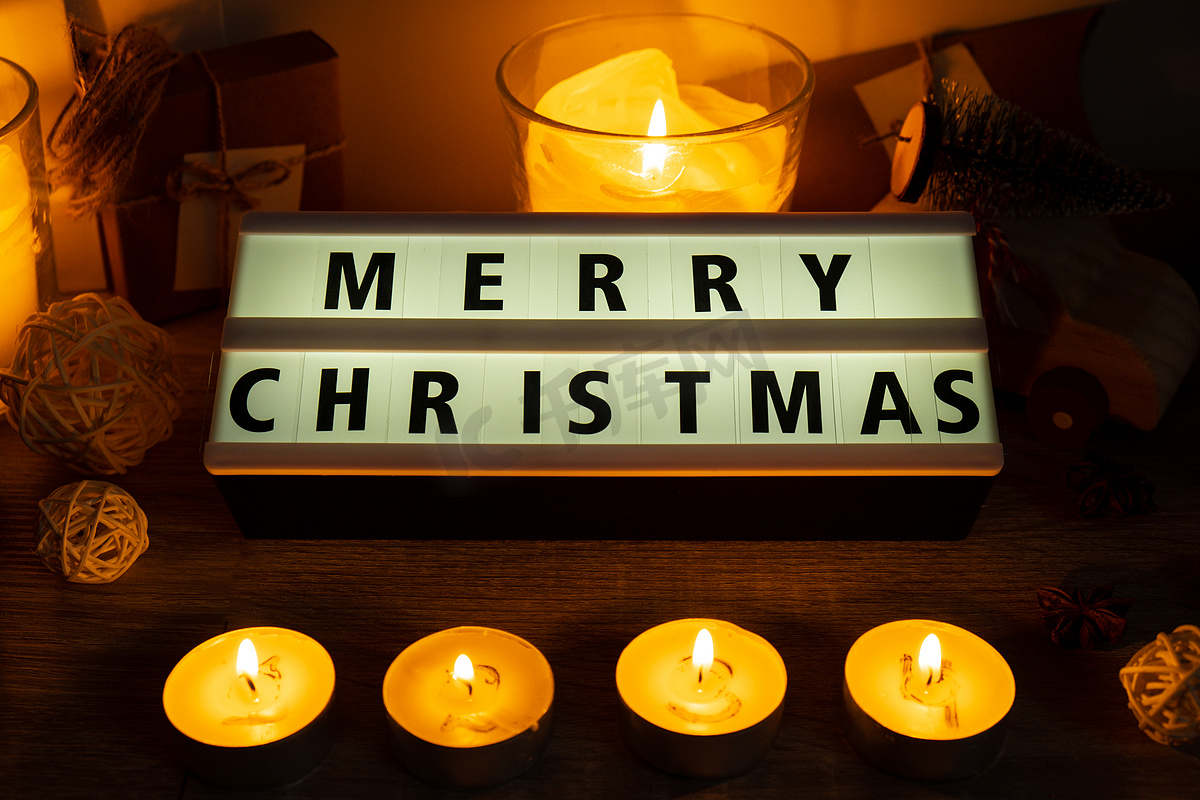 四根蜡烛，带有出现日历灯箱，上面有文字“圣诞快乐”传统燃烧的圣诞蜡蜡烛，上面有圣诞节倒计时的数字。图片
