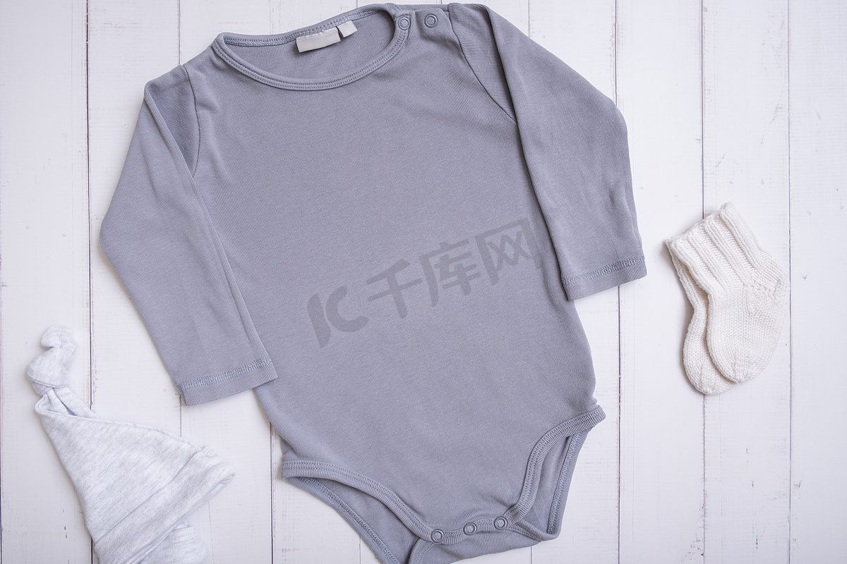 灰色婴儿紧身衣模型，用于木质背景上的徽标、文字或设计，带帽子和袜子顶视图图片