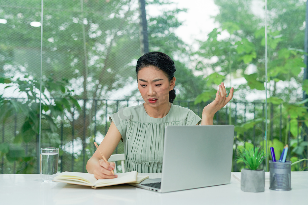 压力大的迷人女士因艰苦的工作任务或系统崩溃而烦恼。图片