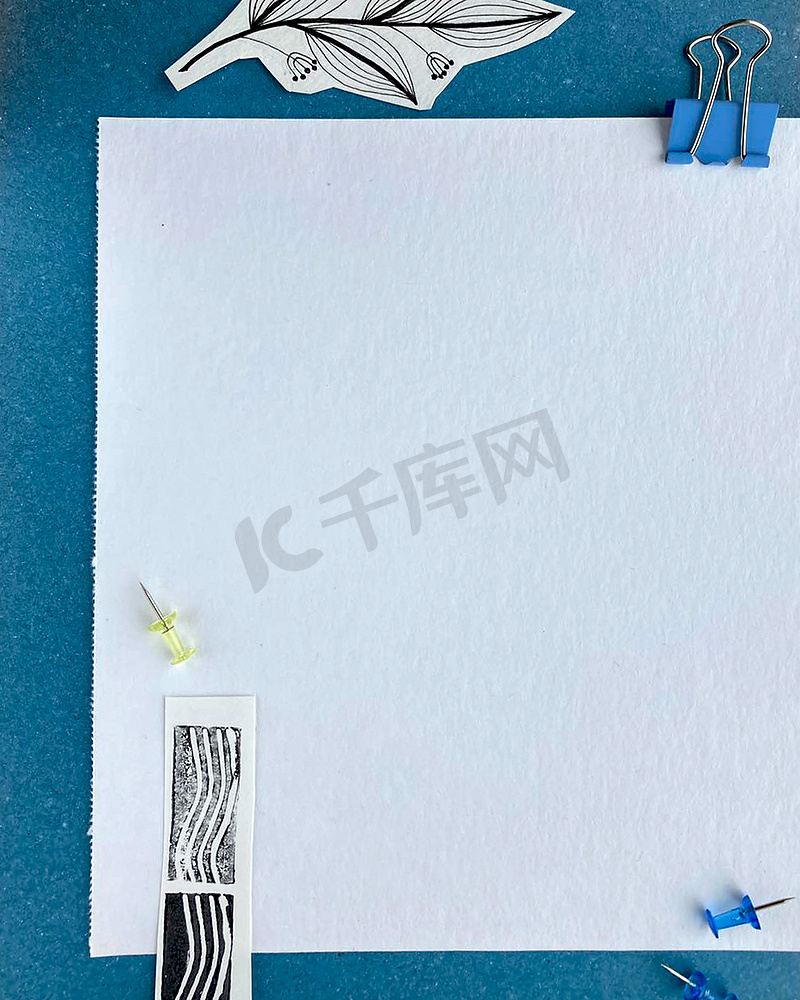 蓝色背景空纸提醒上的明信片模型或带有邮票和剪纸涂鸦分支手绘的列表纸。图片