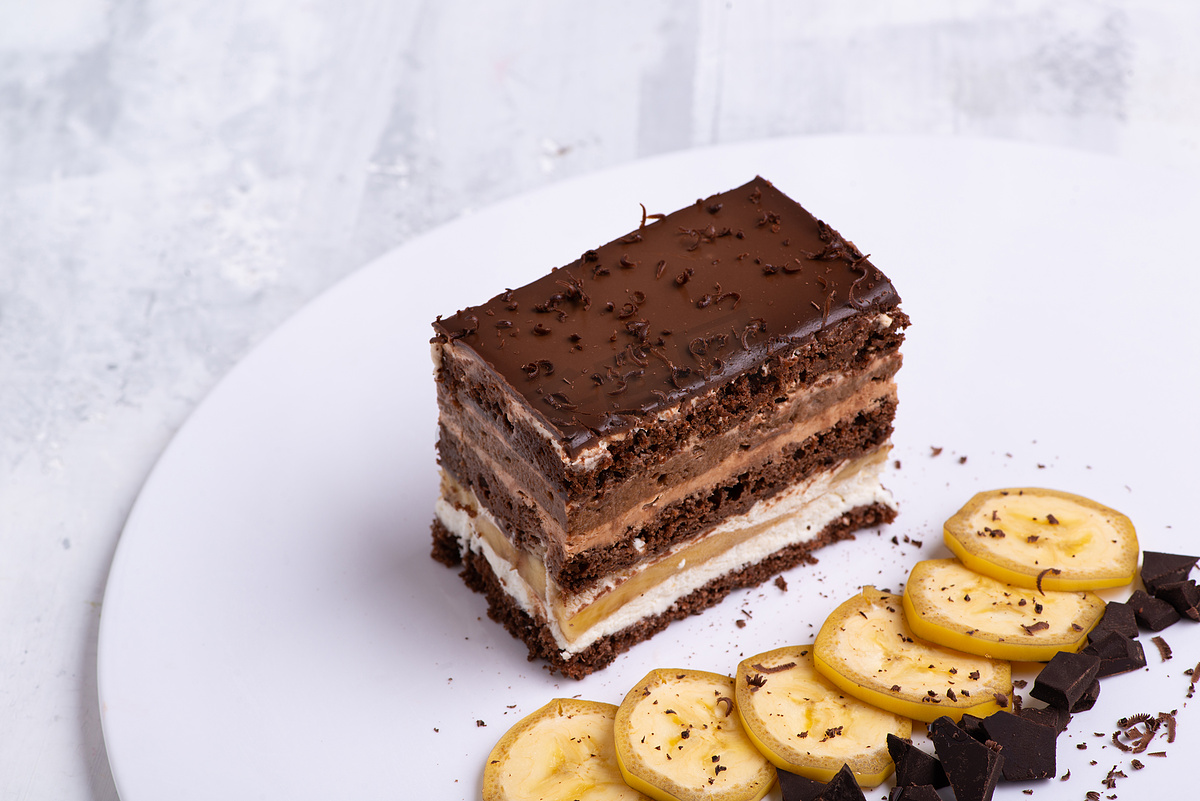 在白盘上供应美味的巧克力蛋糕片图片