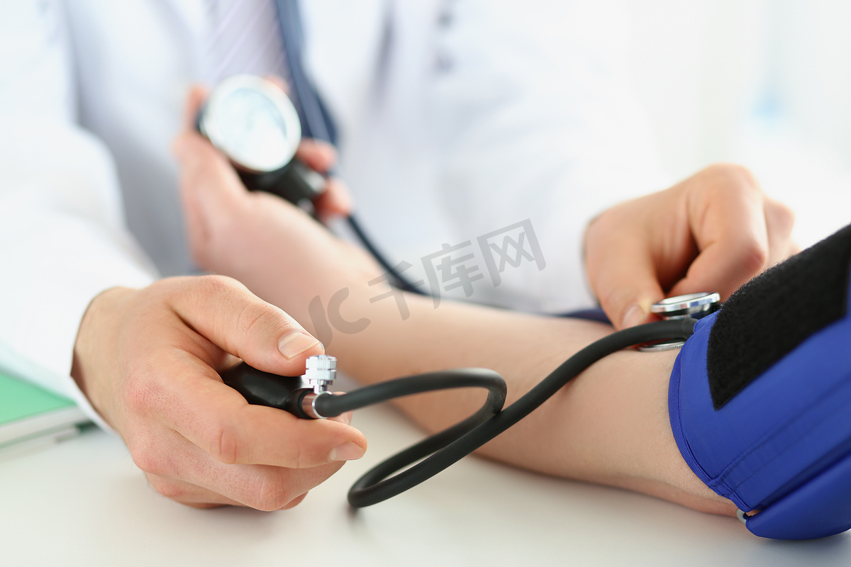 医生在诊所检查病人的血压，高血压的风险，预防疾病图片