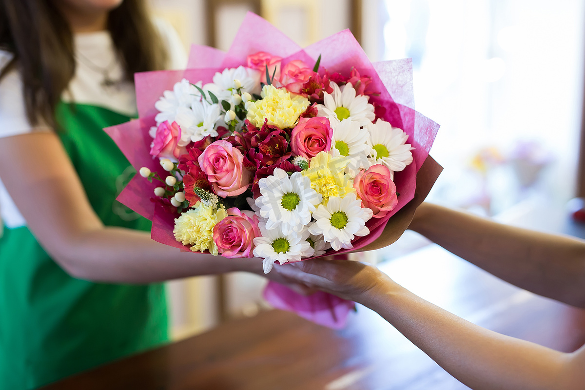 花店会给顾客一束美丽的鲜花。图片