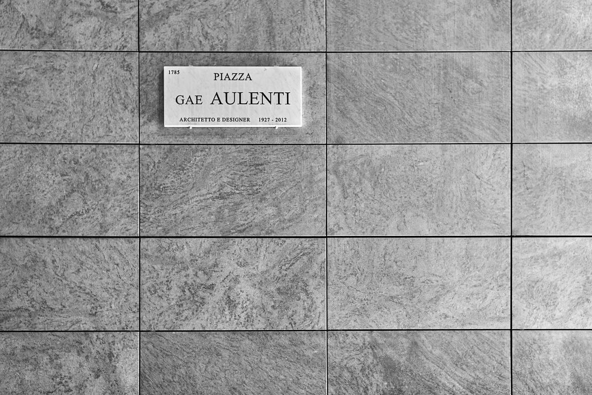 带有标志的天然灰色花岗岩瓷砖墙 - Piazza Gae Aulenti, architetto e designer - 意思是 Gae Aulenti 广场，建筑师和设计师。 图片