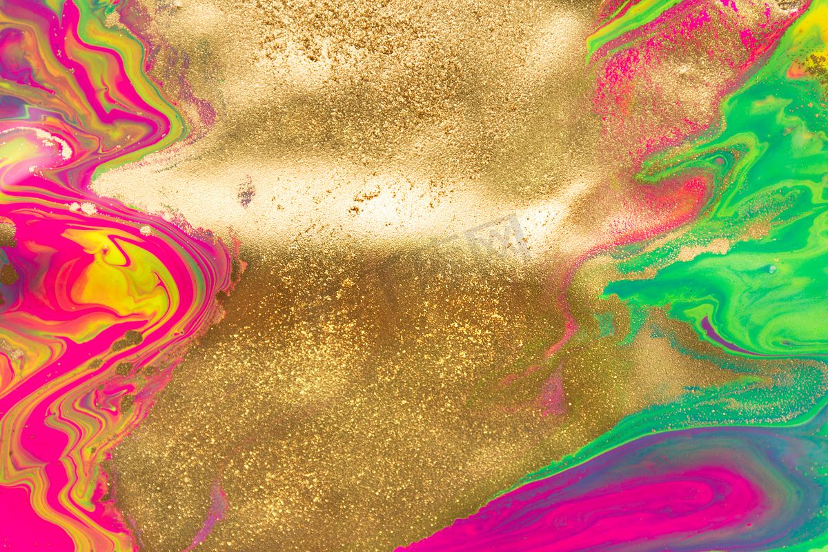 液体荧光涂料背景上的金粉斑点。图片