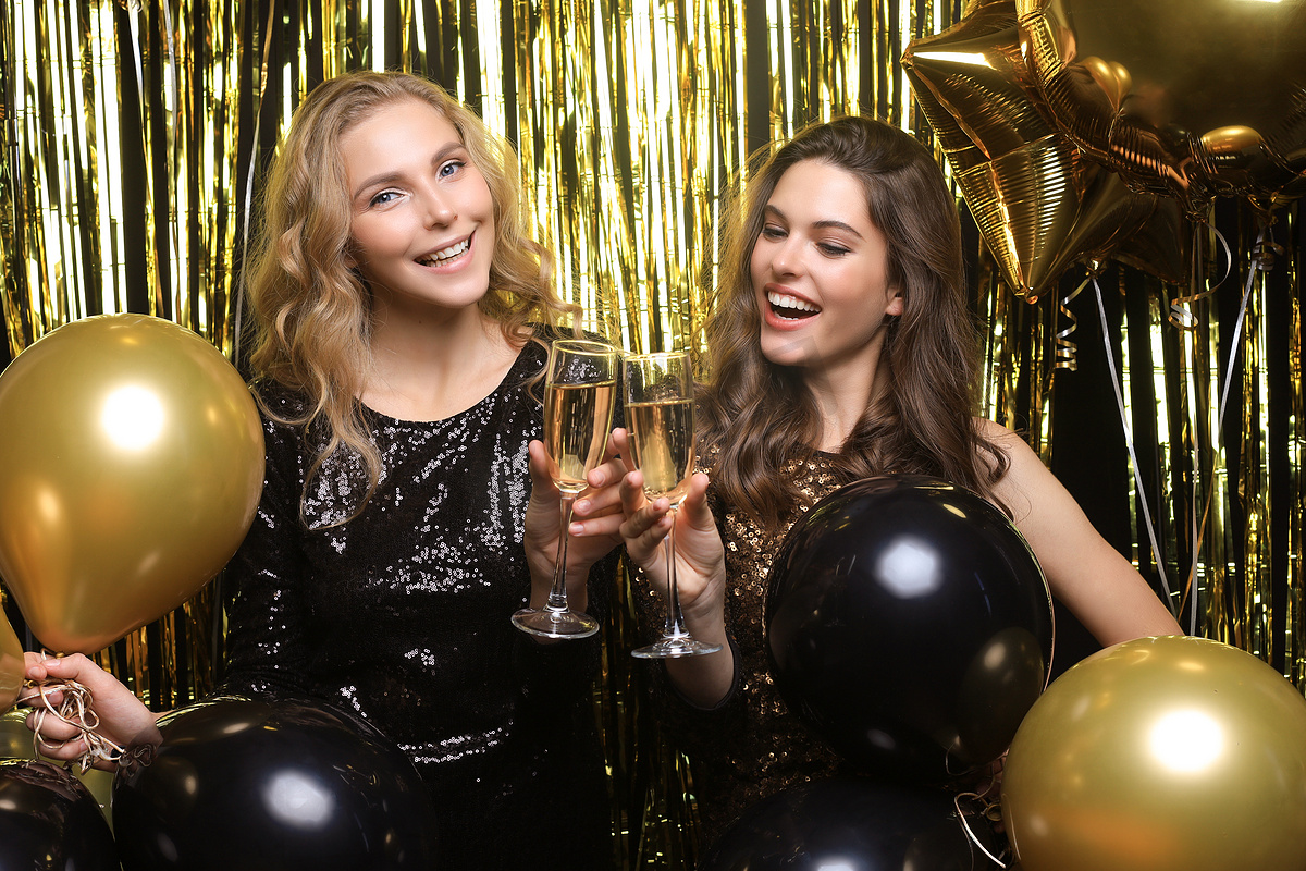 两位年轻女士正在喝香槟。图片