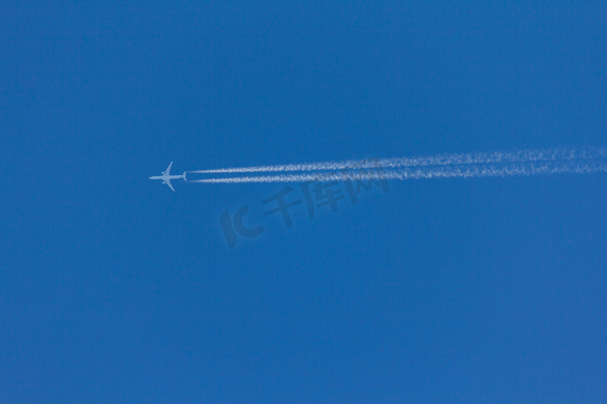 飞行的飞机在空中留下一条反转轨迹图片
