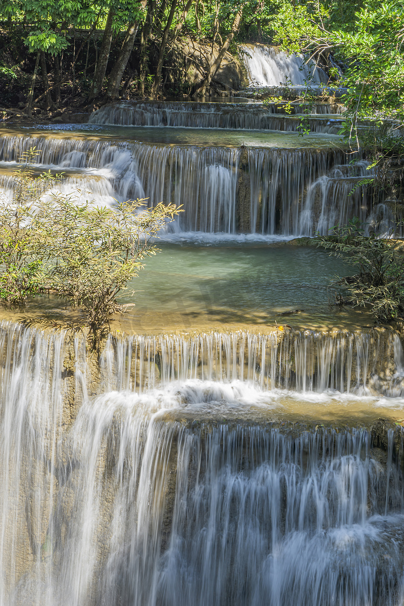 瀑布清澈的水在黄色的石灰岩中循环。图片
