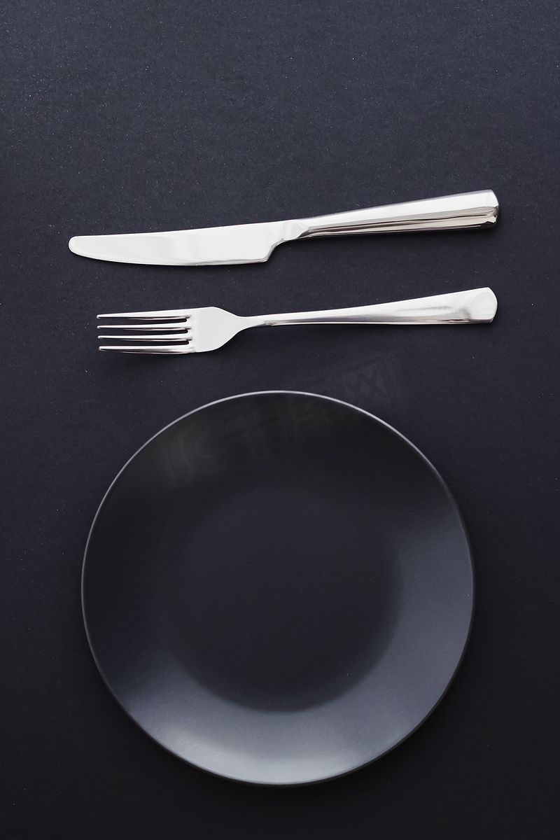 黑色背景的空盘子和银器、节日晚餐的优质餐具、简约的设计和饮食图片