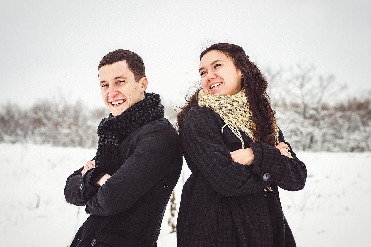 一个穿着暖和的衣服和围巾的男孩和女孩在雪天散步图片
