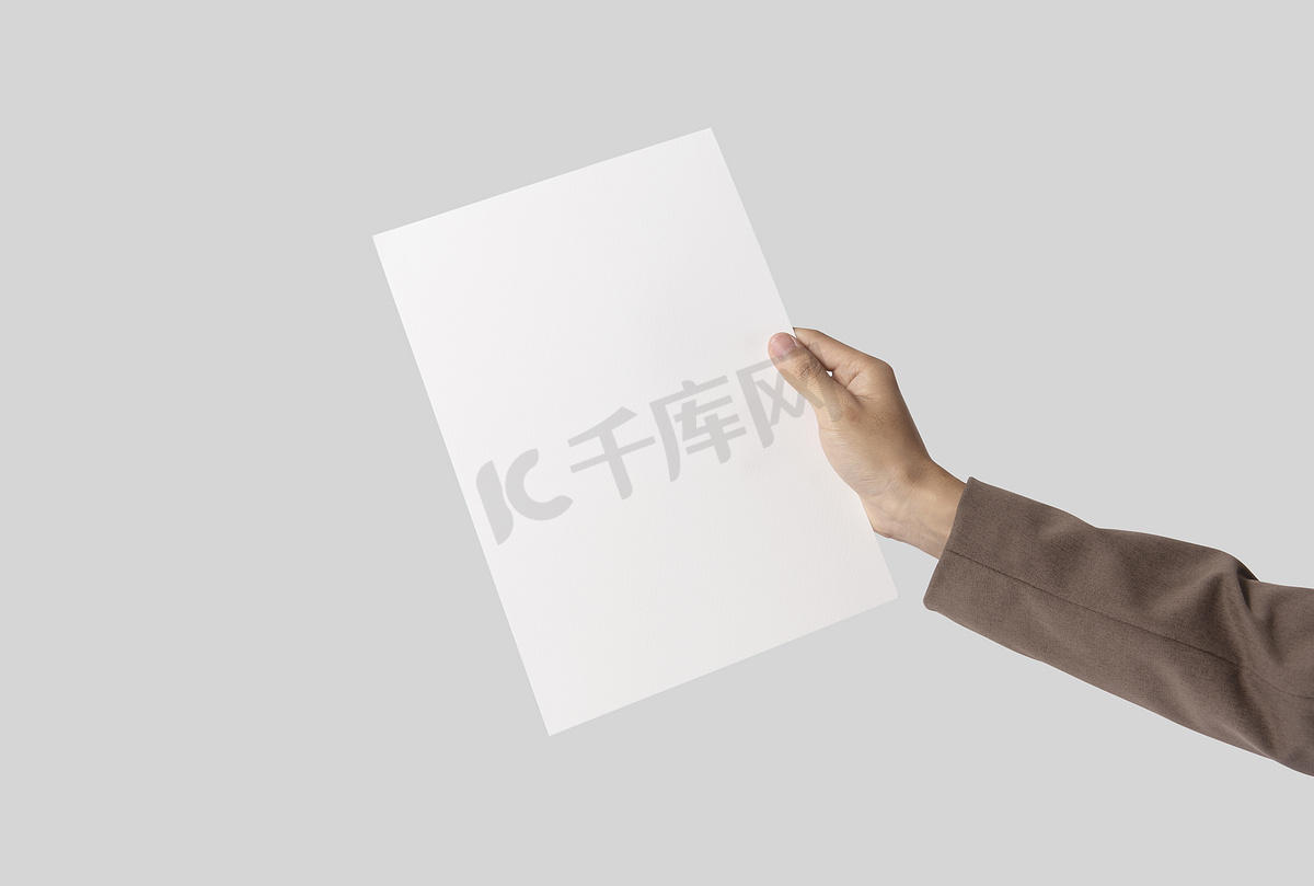 手在灰色背景上展示空白纸 A4 传单，用于样机模板徽标品牌。图片