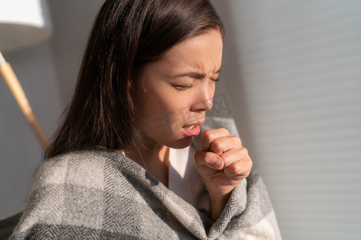 亚洲妇女用拳头咳嗽，因不捂住嘴和鼻子而传播冠状病毒，感染了冠状病毒。图片